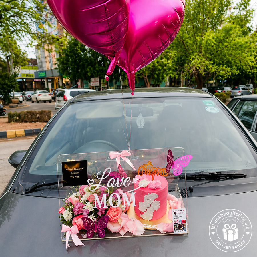 Luxury Mother’s Day acrylic gift box with “Love MOM” text, pink cake, floral arrangement, metallic pink heart balloons