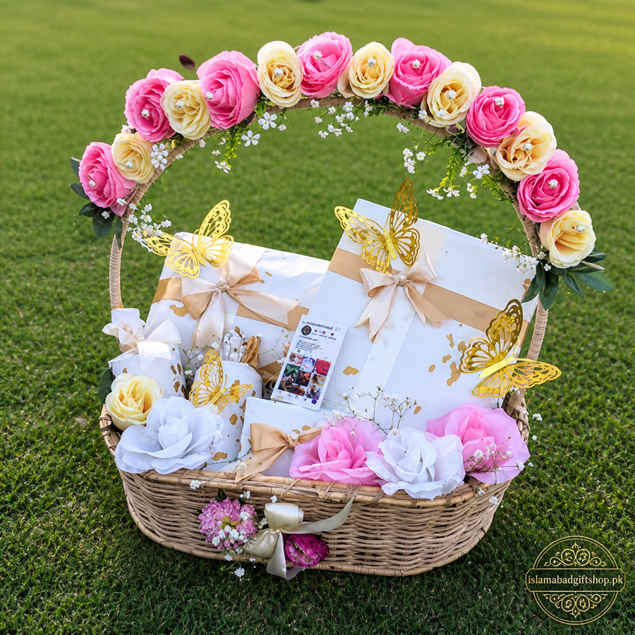 Luxury floral gift basket with pink and cream roses, golden butterflies, wrapped dresses, perfume, chocolates