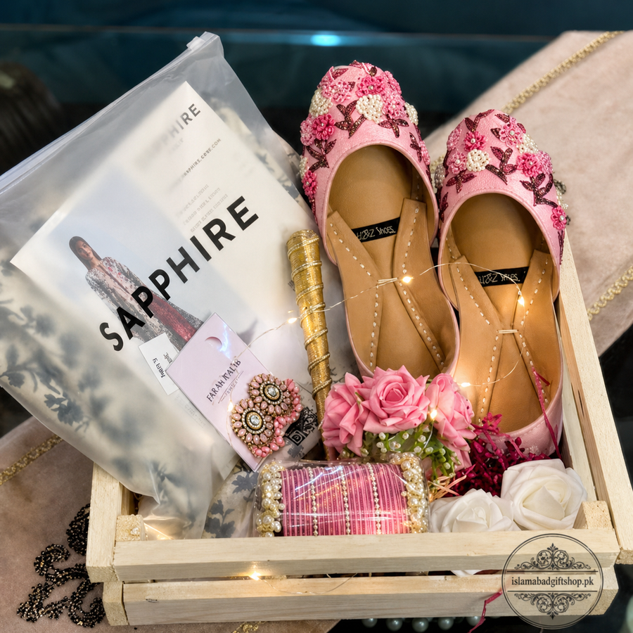 Decorative pink shoes with floral embellishments in a box with 'Sapphire' magazine and other decorative items.