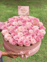 Pink Mother’s Day rose box filled with blush and pink roses, featuring a Happy Mother’s Day topper, gold butterfly decoration, satin bow.