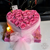 Heart-shaped pink rose arrangement with fairy lights, pink net wrapping, large bow, butterfly decor, candle