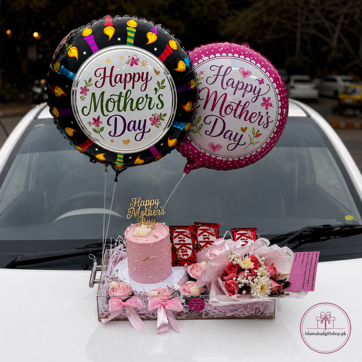 Luxury Mother’s Day gift tray with Happy Mother’s Day balloons, pink cake, flower bouquet, chocolates, ribbons, greeting card.